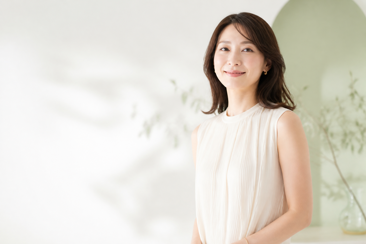 明るい空間で自然に立つノースリーブ姿の女性